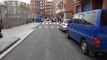 Carrer de l'Abat Marcet acabat d'asfaltar amb cotxes aparcats a la vorera dreta