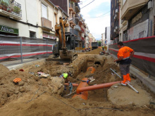 Camí Ral obert per obres amb imatge d'operaris en primer pla i rasa a la calçada