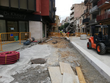 Camí Ral cantonada Jaume Recoder amb part del paviment aixecat i l'altra part, amb asfaltatge provisional. Al fons, formigonera i excavadora