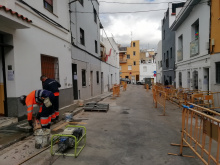 Dos treballadors preparant ciment per reposar vorera amb panot