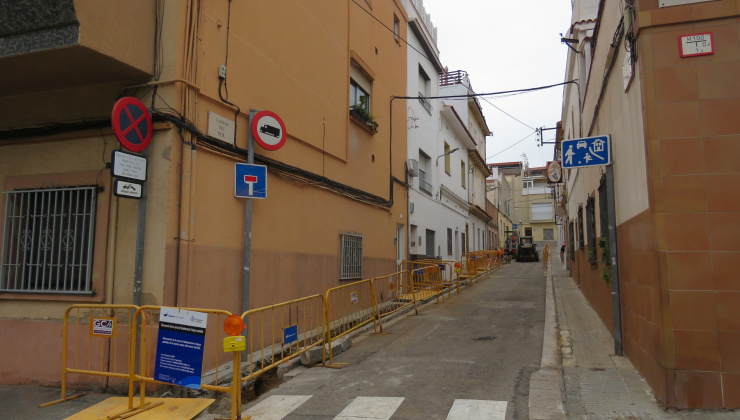 Carrer del Sol en obres amb tanques grogues d'obres a la banda dreta i cartell d'Aigües de Mataró en primer plà.