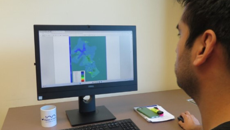 Doctorat industrial teballant davant d'un ordinador, amb un model de l'aquïfer en pantalla